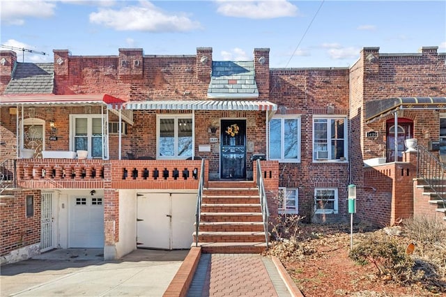 view of front of home with a garage, concrete driveway, and brick siding