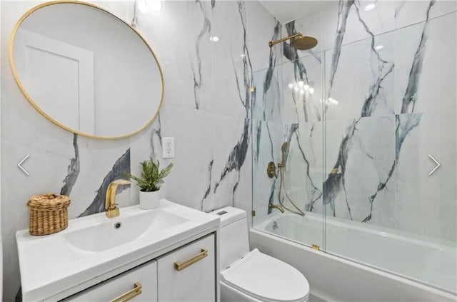 full bathroom featuring toilet, vanity, and bath / shower combo with glass door