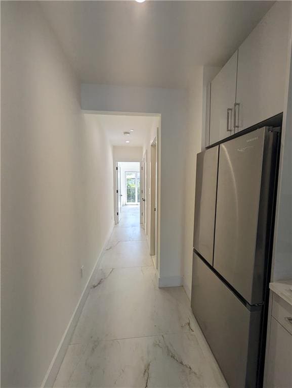 corridor featuring baseboards and marble finish floor