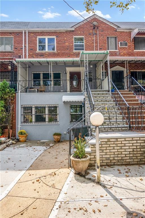 multi unit property with brick siding, stairway, and stucco siding