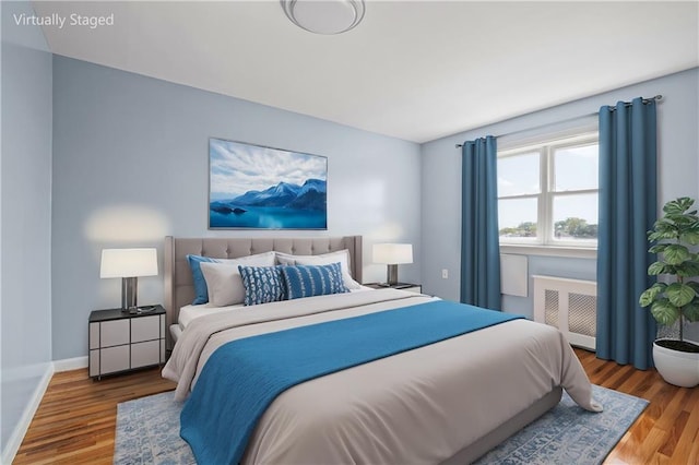 bedroom featuring hardwood / wood-style flooring and radiator heating unit