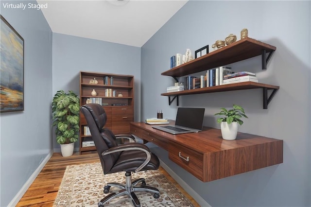 home office featuring vaulted ceiling and light hardwood / wood-style floors