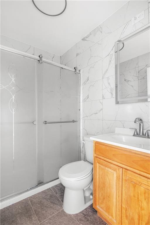 bathroom featuring vanity, toilet, tile walls, and walk in shower