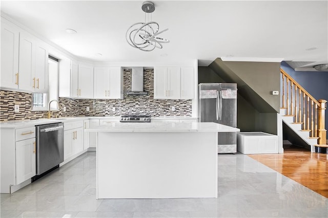 kitchen with stainless steel appliances, white cabinetry, wall chimney exhaust hood, a notable chandelier, and marble finish floor