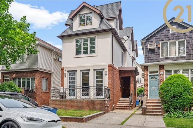 view of front of house featuring entry steps, brick siding, and stucco siding