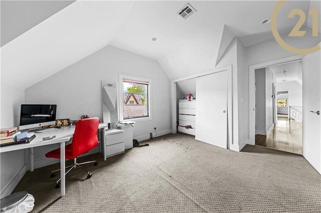 home office with carpet, visible vents, and lofted ceiling