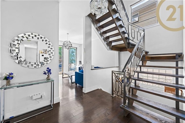 entrance foyer with baseboards, stairs, a chandelier, and dark wood-style flooring