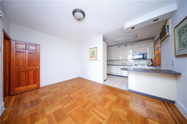 kitchen with white appliances, a textured ceiling, white cabinets, and light parquet flooring