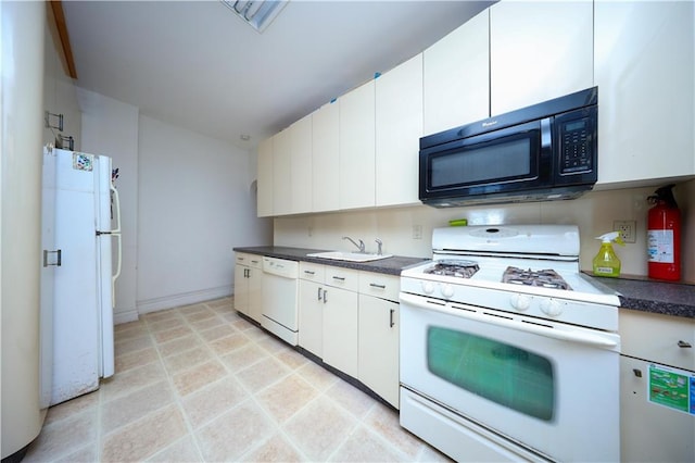 kitchen featuring dark countertops, white appliances, white cabinets, and a sink