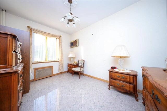 sitting room with a wall mounted AC, radiator heating unit, and an inviting chandelier