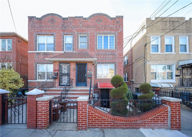 view of front of home featuring a fenced front yard, a gate, and brick siding