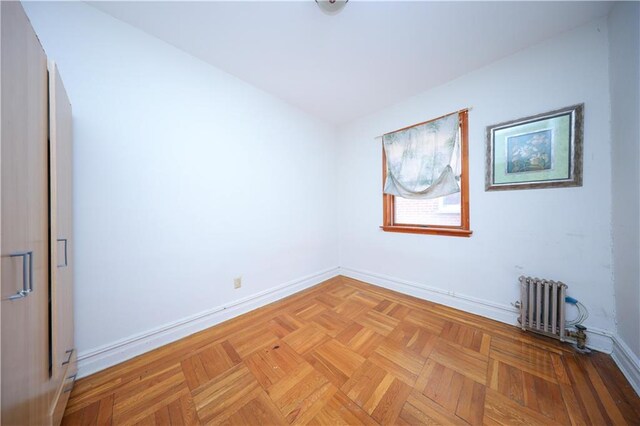 unfurnished room featuring light parquet flooring and radiator