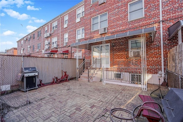 view of patio with grilling area, cooling unit, and fence private yard