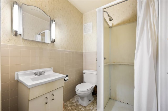 bathroom with vanity, tile walls, walk in shower, and toilet