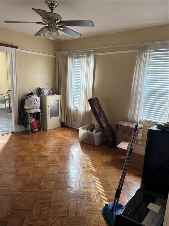 interior space featuring ceiling fan, parquet flooring, and plenty of natural light