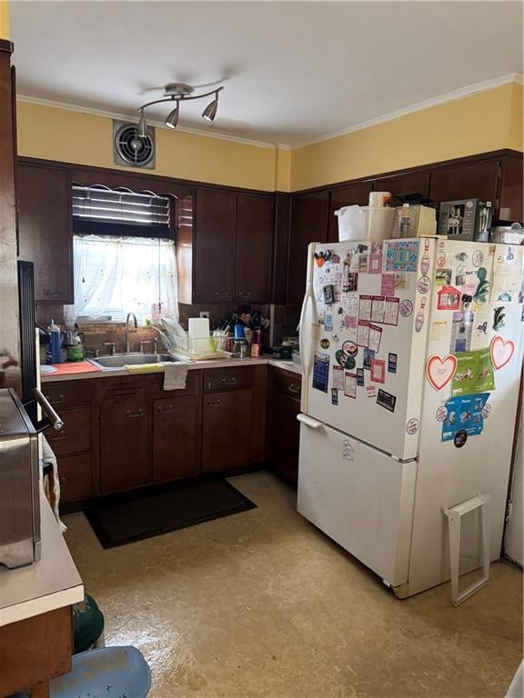 kitchen with white refrigerator, crown molding, dark brown cabinets, and sink