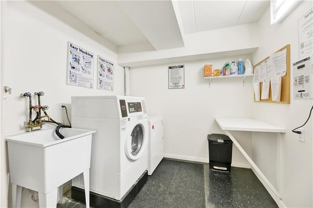 shared laundry area featuring baseboards, a sink, and independent washer and dryer