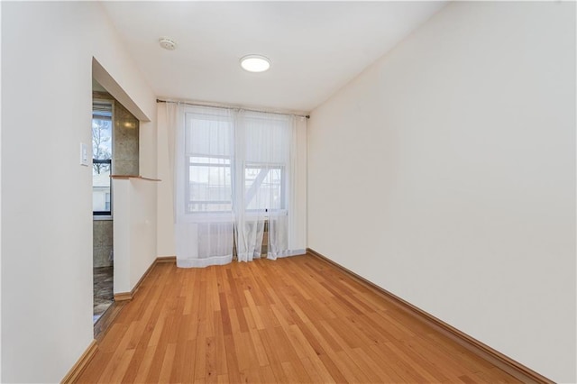 empty room featuring baseboards and light wood-style floors