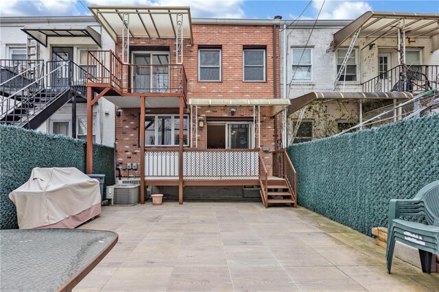 back of property with brick siding and central AC