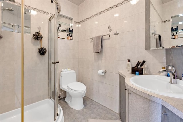 full bathroom featuring tile walls, toilet, a stall shower, vanity, and tile patterned flooring