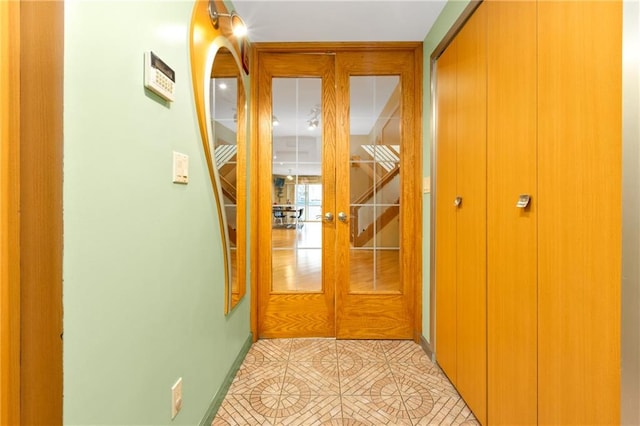 corridor with light tile patterned flooring and baseboards