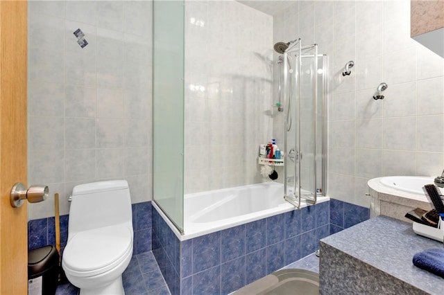 bathroom with tiled shower / bath, tile walls, and toilet