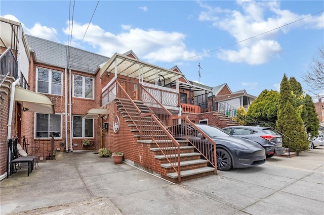 view of front of property featuring brick siding and stairway