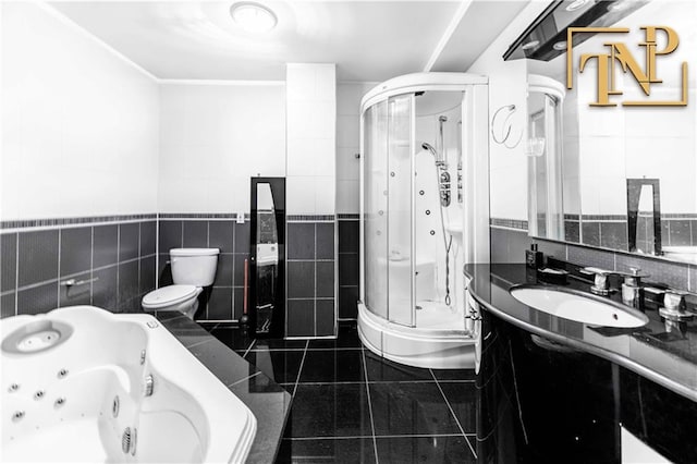 bathroom featuring tile patterned floors, a stall shower, tile walls, and vanity