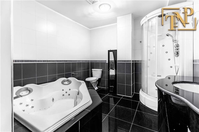 bathroom featuring a jetted tub, toilet, tile walls, and a shower stall