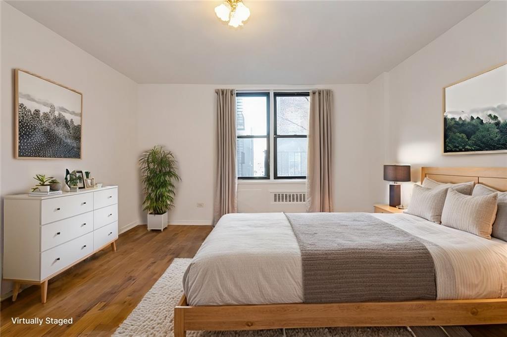 bedroom featuring radiator heating unit and hardwood / wood-style floors