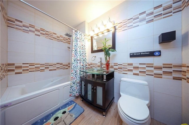 full bathroom with hardwood / wood-style floors, sink, tile walls, toilet, and shower / bathtub combination with curtain