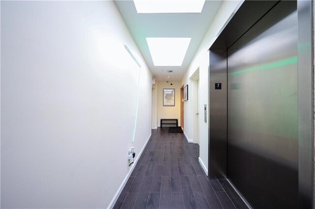 hallway featuring a skylight, dark hardwood / wood-style floors, and elevator