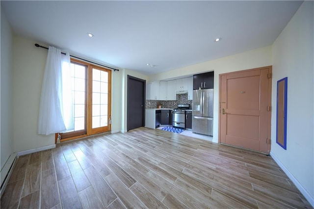 unfurnished living room featuring a baseboard heating unit and light hardwood / wood-style flooring