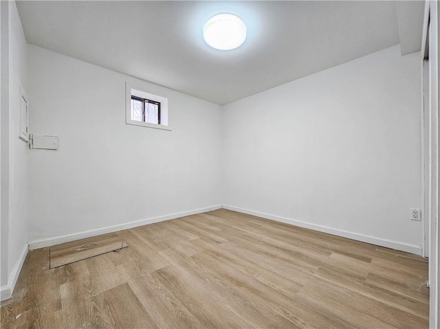 spare room featuring light wood-style flooring and baseboards