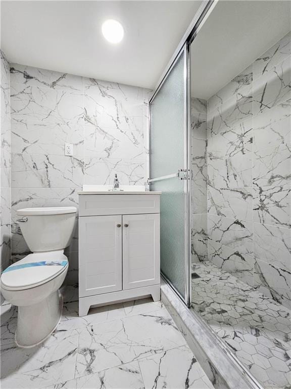 bathroom with stone wall, toilet, vanity, marble finish floor, and a marble finish shower