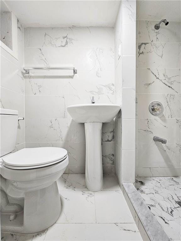 full bath featuring marble finish floor, a shower, and toilet