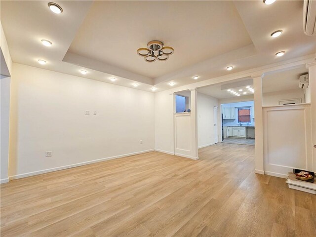 unfurnished room featuring a raised ceiling and light wood-type flooring