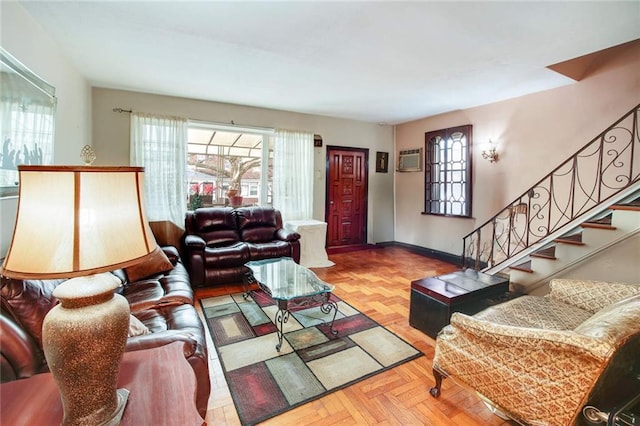 living area featuring stairs, baseboards, a wealth of natural light, and an AC wall unit