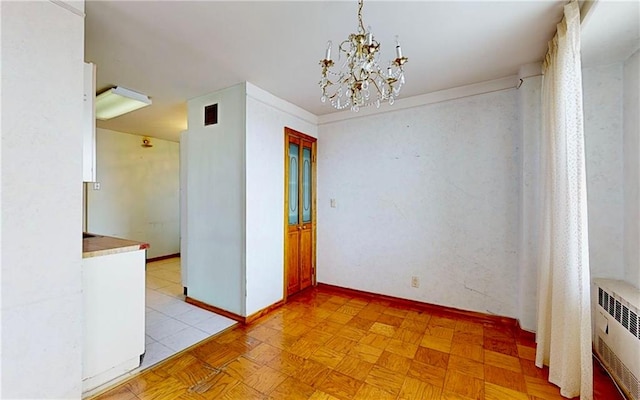 unfurnished room with an inviting chandelier, radiator, and light parquet floors