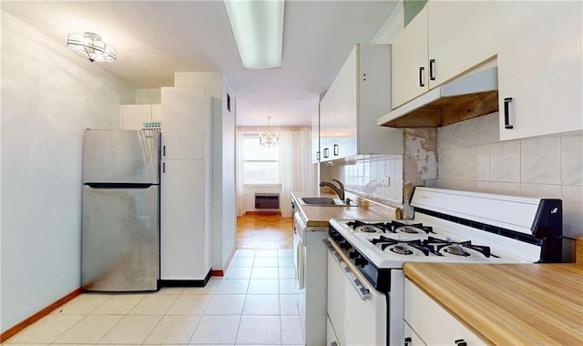 kitchen with white cabinetry, sink, stainless steel fridge, and gas range gas stove