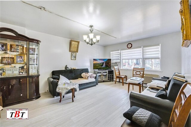 living room with a notable chandelier and light hardwood / wood-style floors