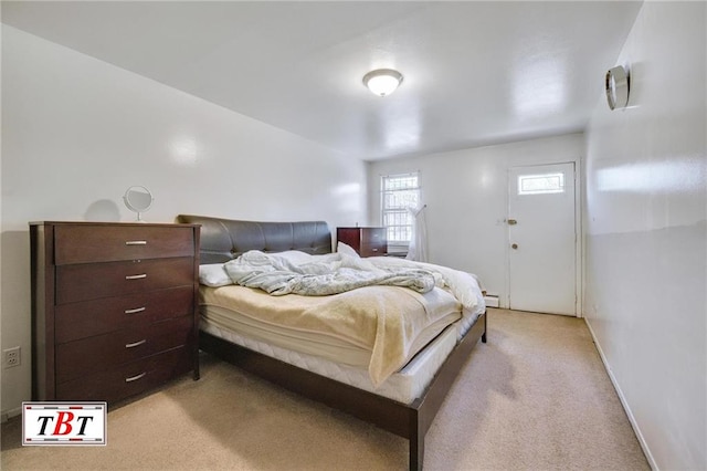 bedroom featuring baseboards and light carpet