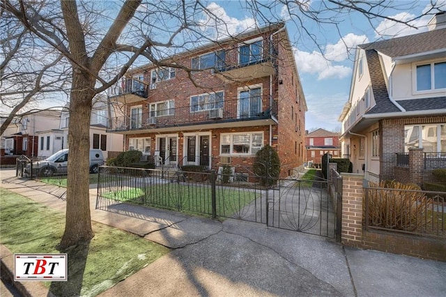 view of front of home featuring brick siding and a fenced front yard