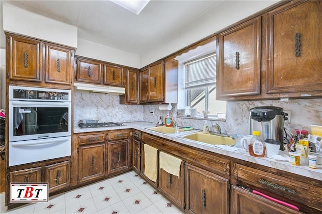 kitchen featuring white oven, gas cooktop, and decorative backsplash