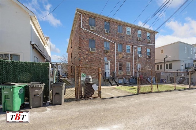 townhome / multi-family property featuring a gate, brick siding, and fence