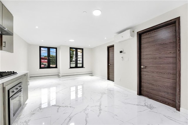 interior space with baseboards, a wall unit AC, marble finish floor, stainless steel oven, and recessed lighting