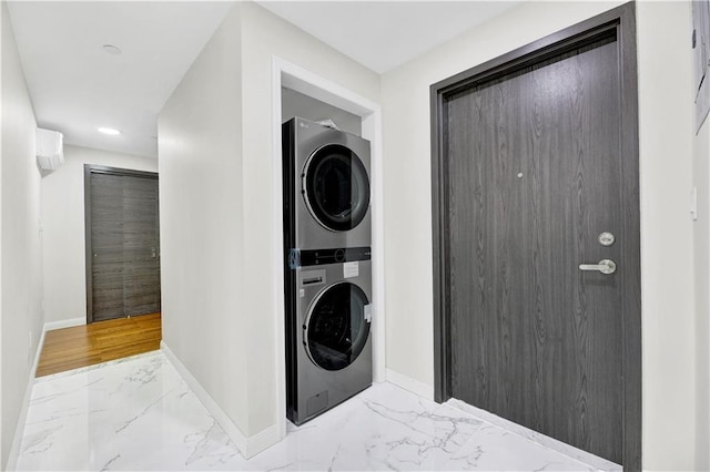 laundry area featuring marble finish floor, baseboards, laundry area, and stacked washer and clothes dryer