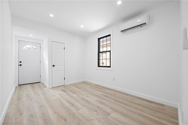 foyer entrance featuring baseboards, an AC wall unit, recessed lighting, and light wood-style floors