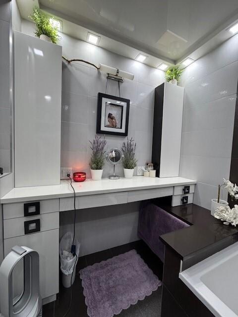 bathroom with decorative backsplash, vanity, tile patterned flooring, and tile walls