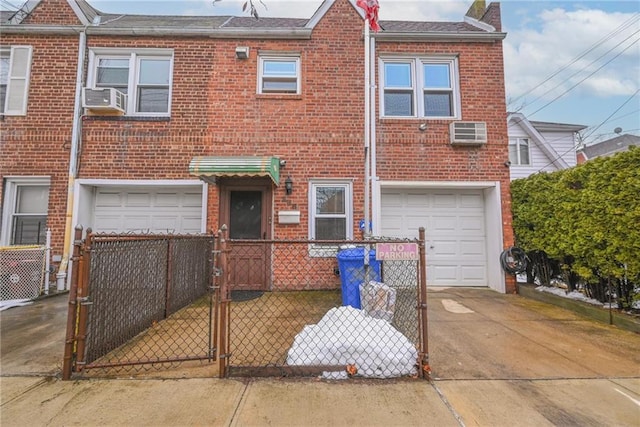 view of front of home featuring a garage, an AC wall unit, and cooling unit